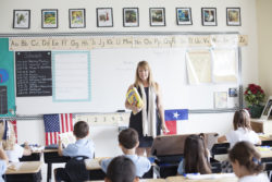 A teacher delivers instructions regarding a textbook