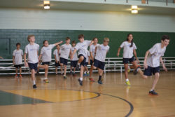 A few people in a group of exercisers crack up with laughter