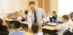 The classroom observers from multiple different angles as the teacher shakes a young learners hand