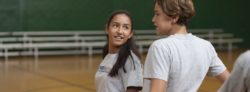 A student talks where the games are played in a gym