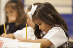 A student thoughts are controlled with school lessons as she writes her schoolwork down