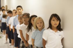 Students stand in a line against the wall